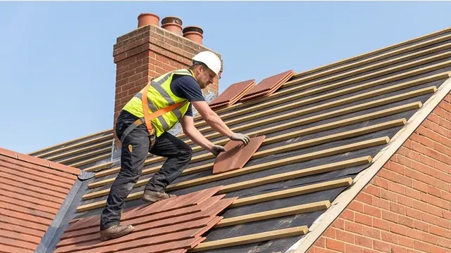Roofer fitting tiles on a pitched roof