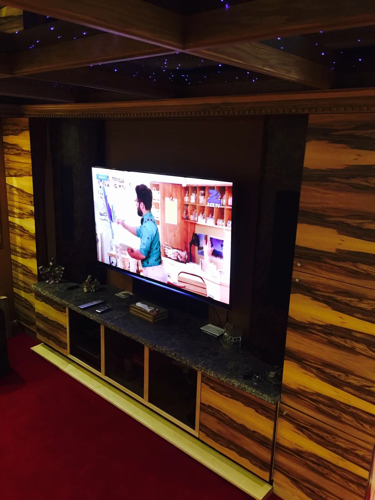 Bespoke home cinema media wall with exotic veneer panelling and fibre-optic starlight ceiling, Sunningdale